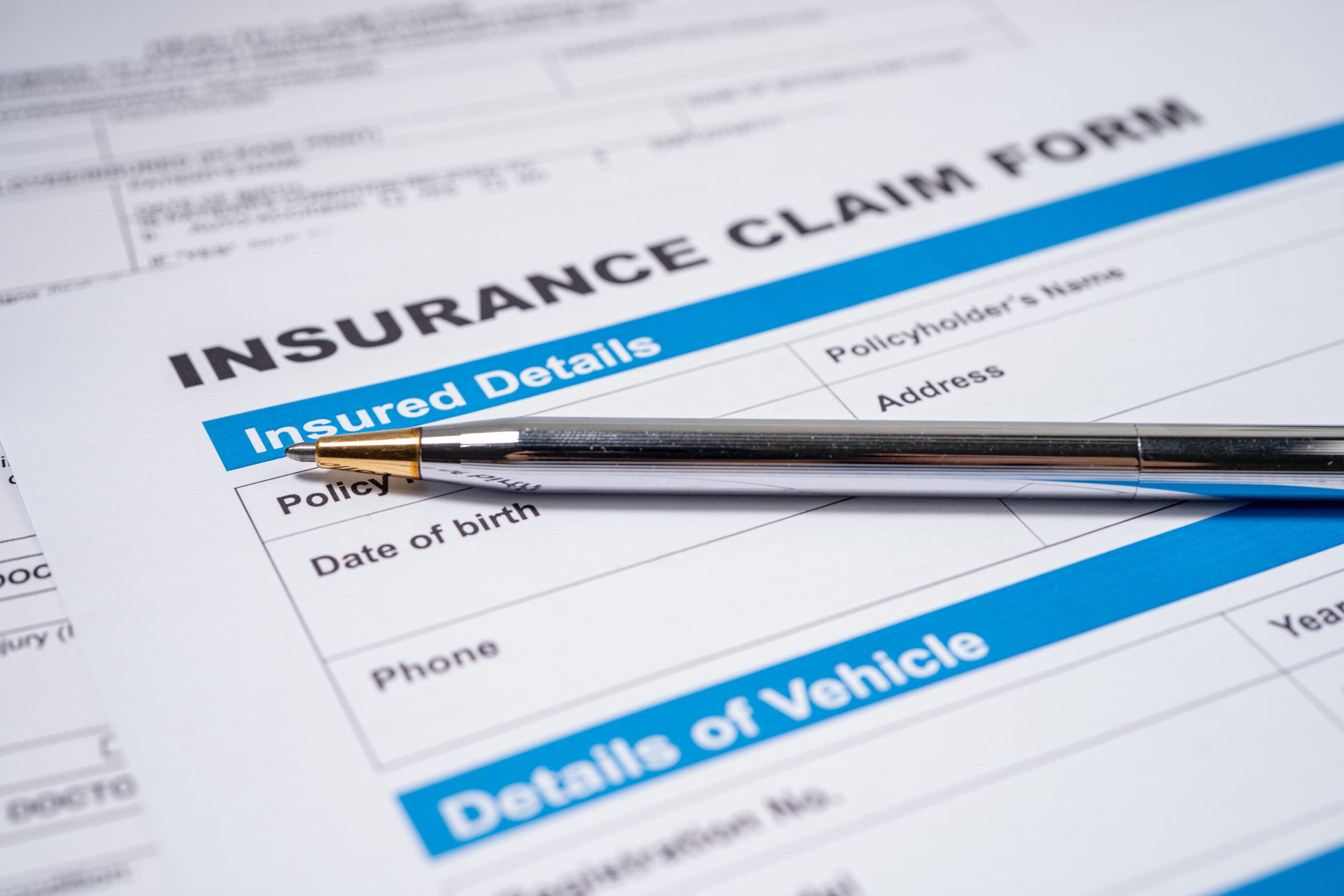 A close up shot of a pen on an insurance claim form