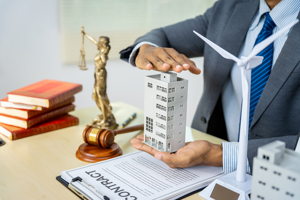 A commercial property lawyer holding a model of an apartment building